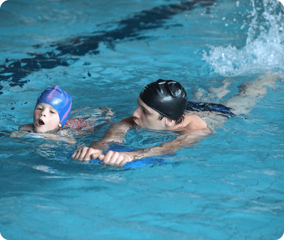 Child learning to swim with instructor