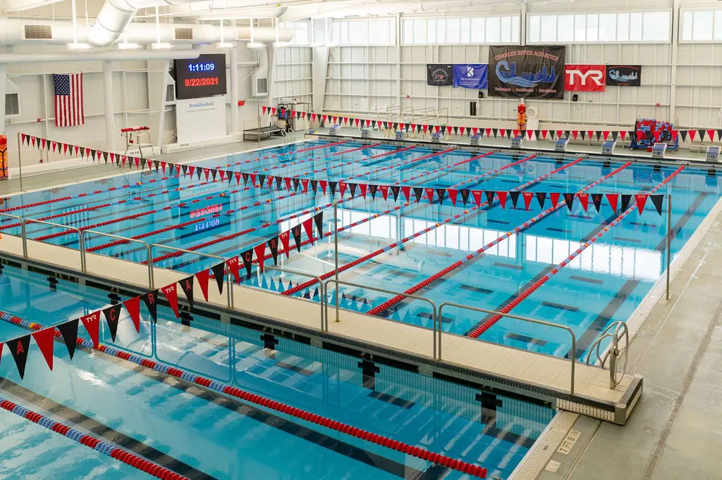 Indoor competitive swimming pool with lane dividers and electronic timing boards.