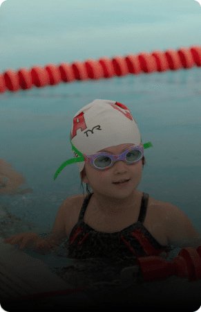 Young swimmer in a pool with goggles.
