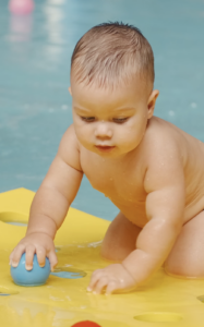 Baby playing with toys on a floating mat.