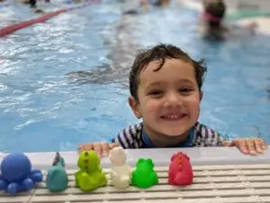 Happy child with colorful bath toys.