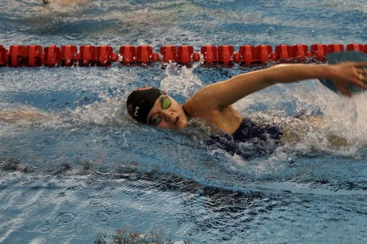 Child practicing freestyle swimming technique.