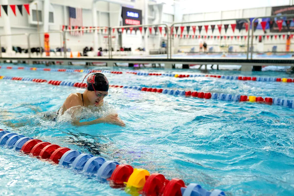 Swimmer in a lane at an indoor pool preparing to swim.