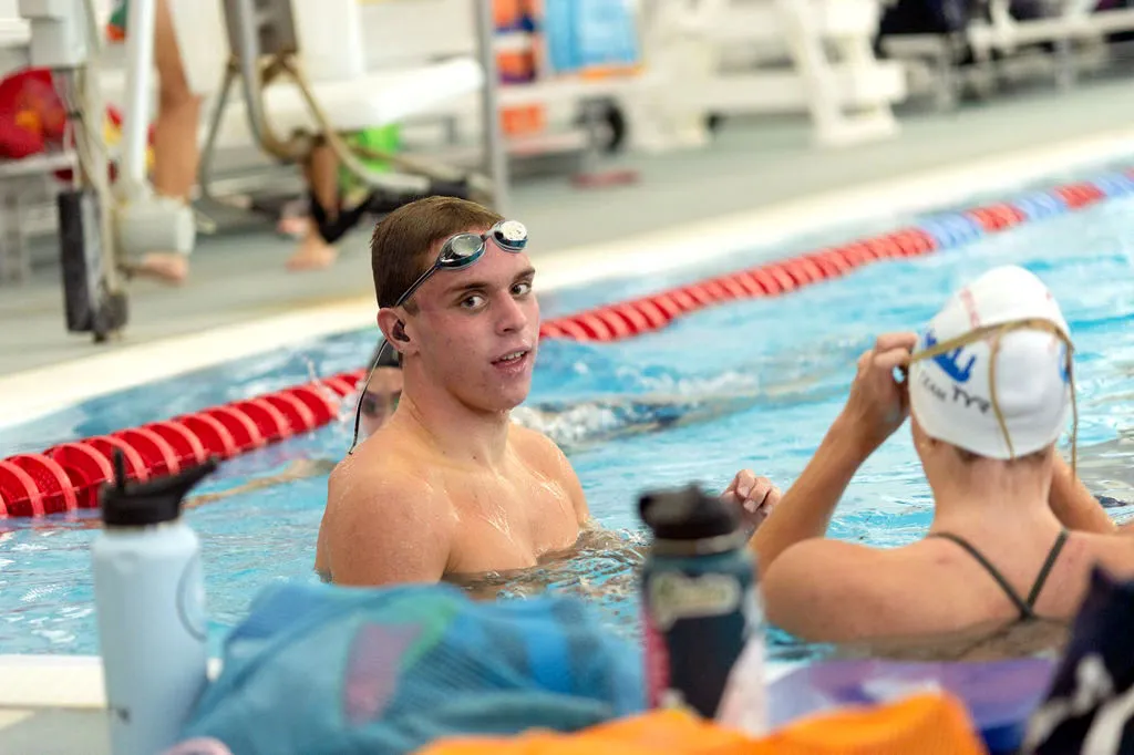 Swimmer wearing goggles in a pool during a break.