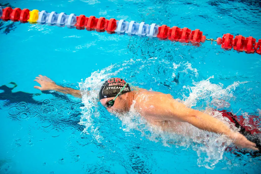 Swimmer performing freestyle stroke in swimming pool